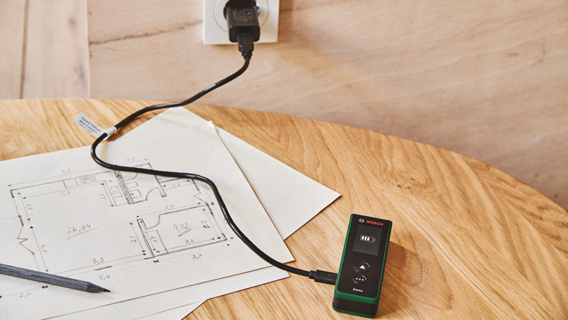 Anwendungsbild, multimeter, elektronisches werkzeug, grünes gerät, ladekabel, holz tisch