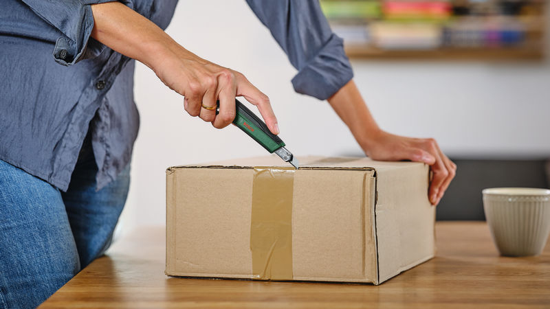 Anwendungsbild, Verpackung, Pappkarton, Klebeband, Cuttermesser, ungeöffneter Karton